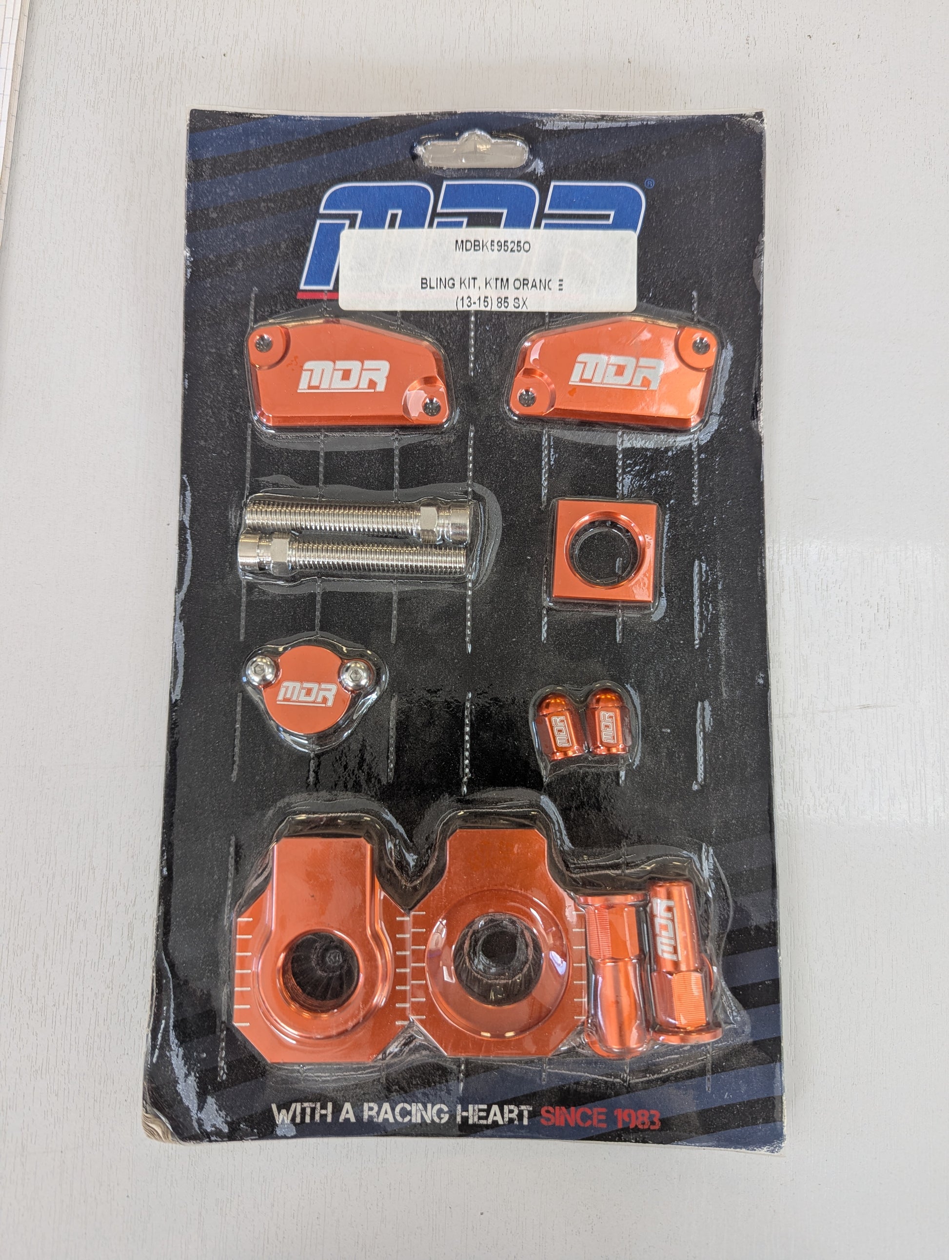 A packaged set of orange and silver bicycle headset components on a black retail card.